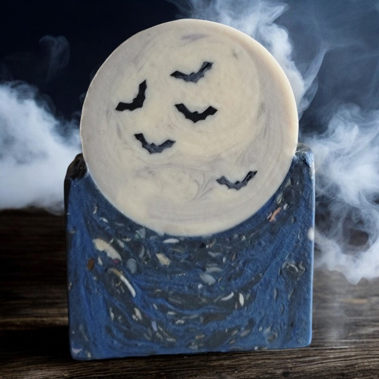 A huge bar of soap with a blue base supporting a full moon with bats flying in front of it