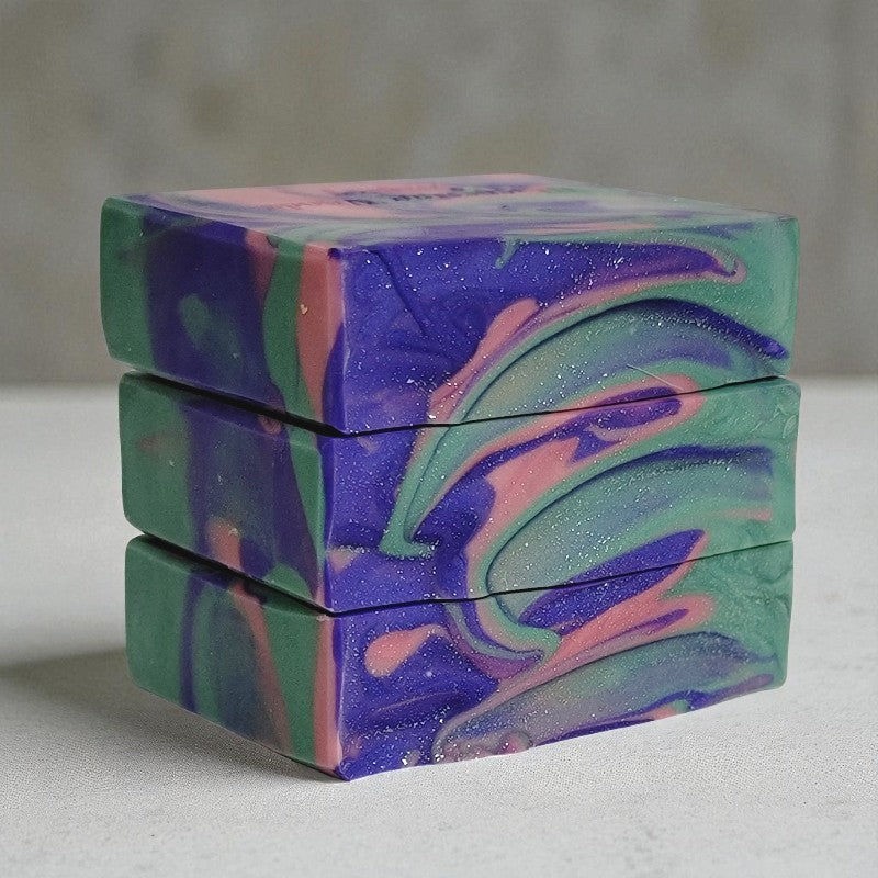 Stack of colorful marbled soap bars on a neutral background