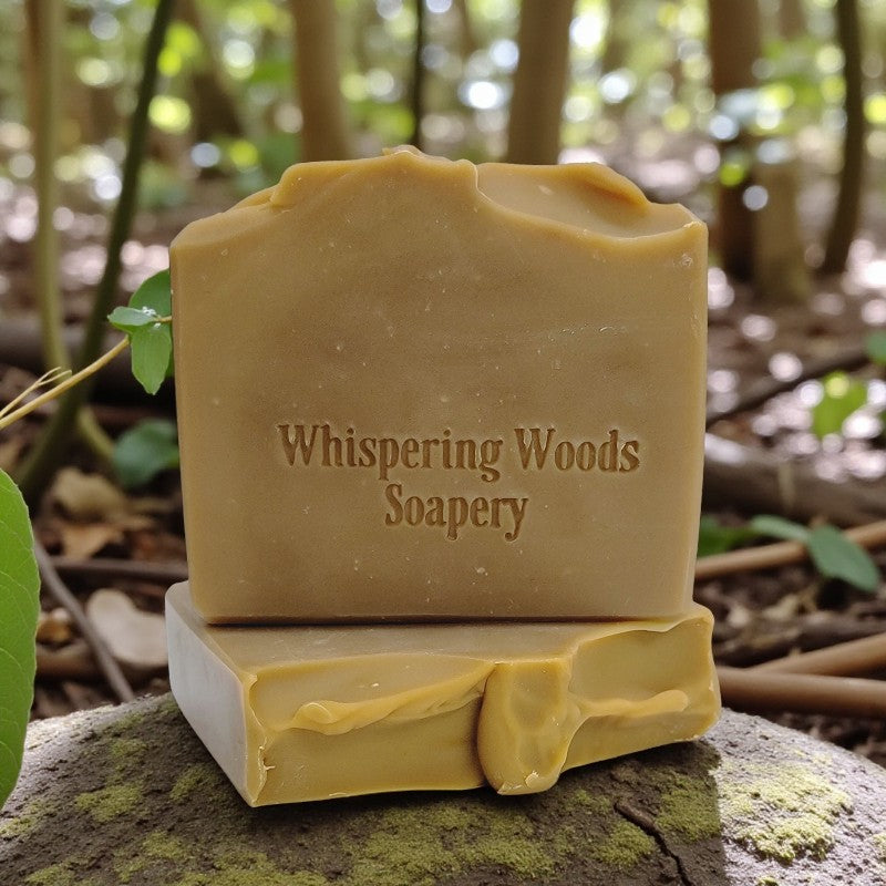 Bars of soap with 'Whispering Woods Soapery' branding on a natural background