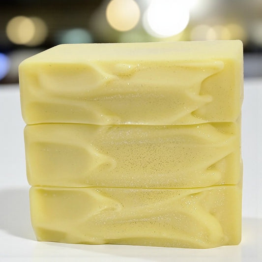 Three bars of yellow soap stacked on a white background