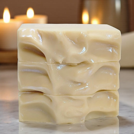 Bars of soap with wavy textured tops stacked on a counter with a neutral background