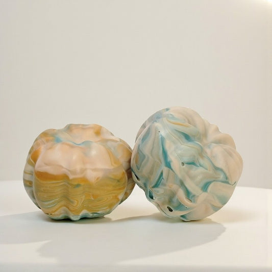 Two pumpkin soaps on a neutral background