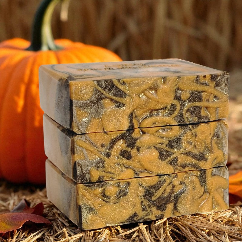 Stack of orange and brown soap bars with a pumpkin in the background