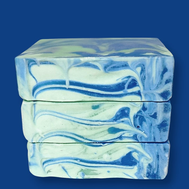 Stack of blue and white marbled soap bars on a blue background