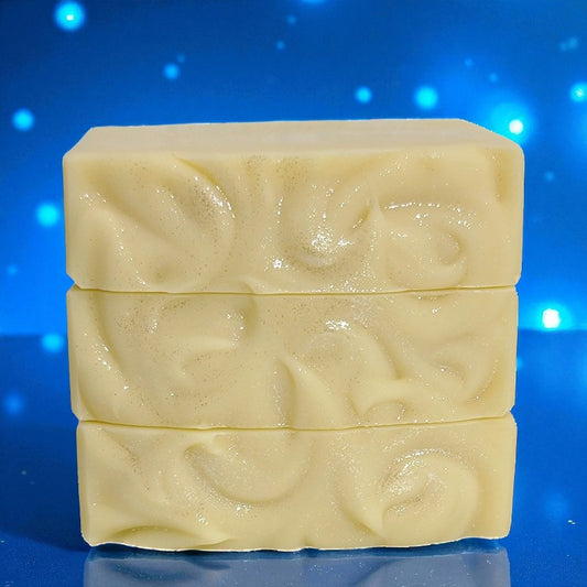 Three stacked pale yellow bars of soap on a blue background