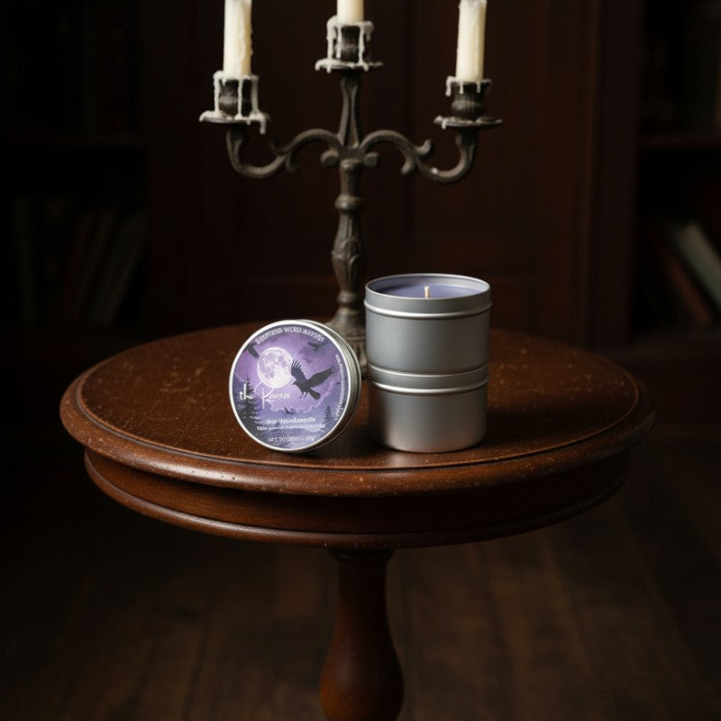 Two candles in metal containers on a wooden table with a dark background