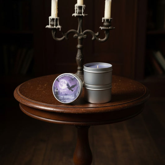 Two candles in metal containers on a wooden table with a dark background