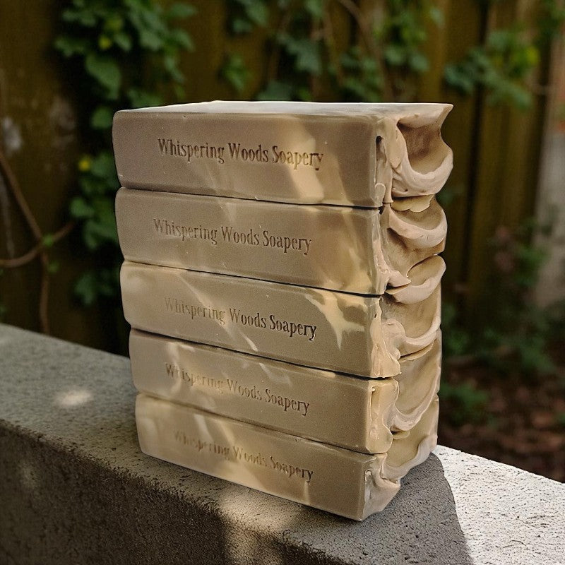 Stack of soap bars from Whispering Woods Soapery on a stone surface with a natural background
