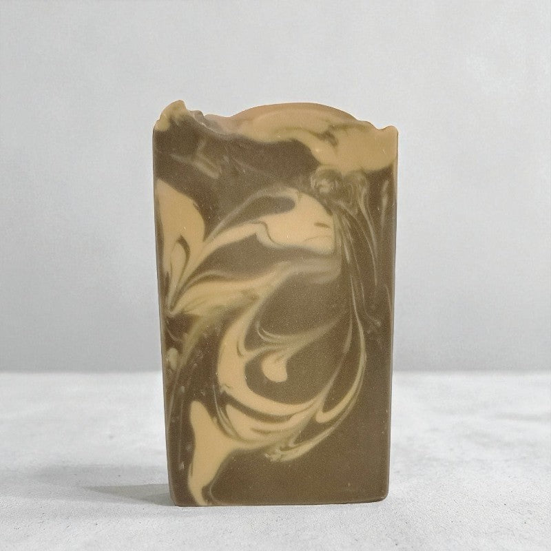Bar of soap with brown and beige swirls on a white background
