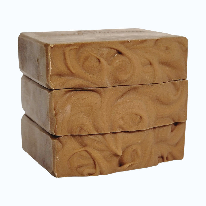 A soap stack showing the textured tops of light brown bars on a white background