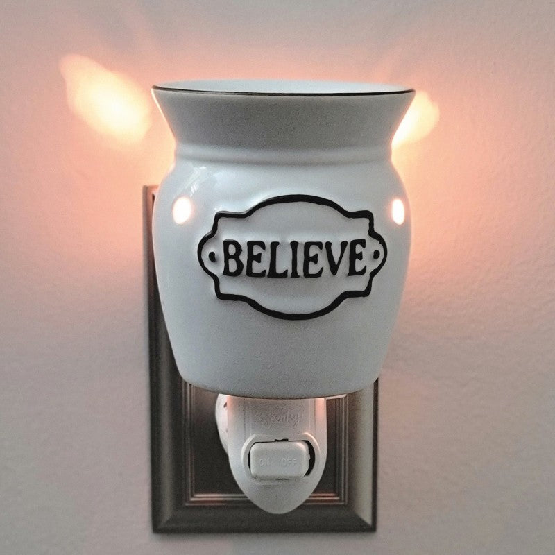 White wax burner with 'BELIEVE' text on a gray wall