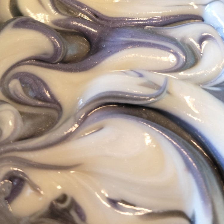 Close-up of freshly-poured soap that has white, gray and light purple swirls