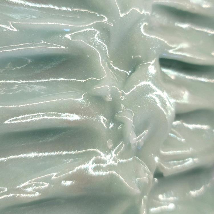 Close-up of freshly poured soap that is a minty-blue color with silver sparkle on the top