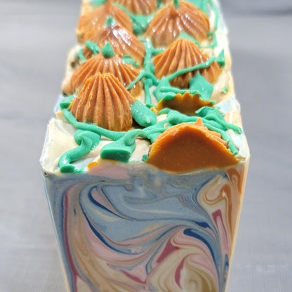 Soap bars with colored swirls of gold, white, orange, blue and pink, with piped orange pumpkins and green leaves/vines on top