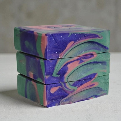 Stack of colorful marbled soap bars on a neutral background