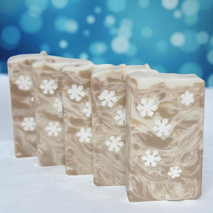 Five bars of soap with snowflake patterns on a blue and white background