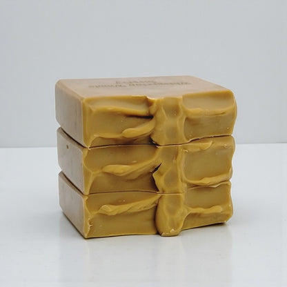 Stack of three gold-brown soap bars on a white background