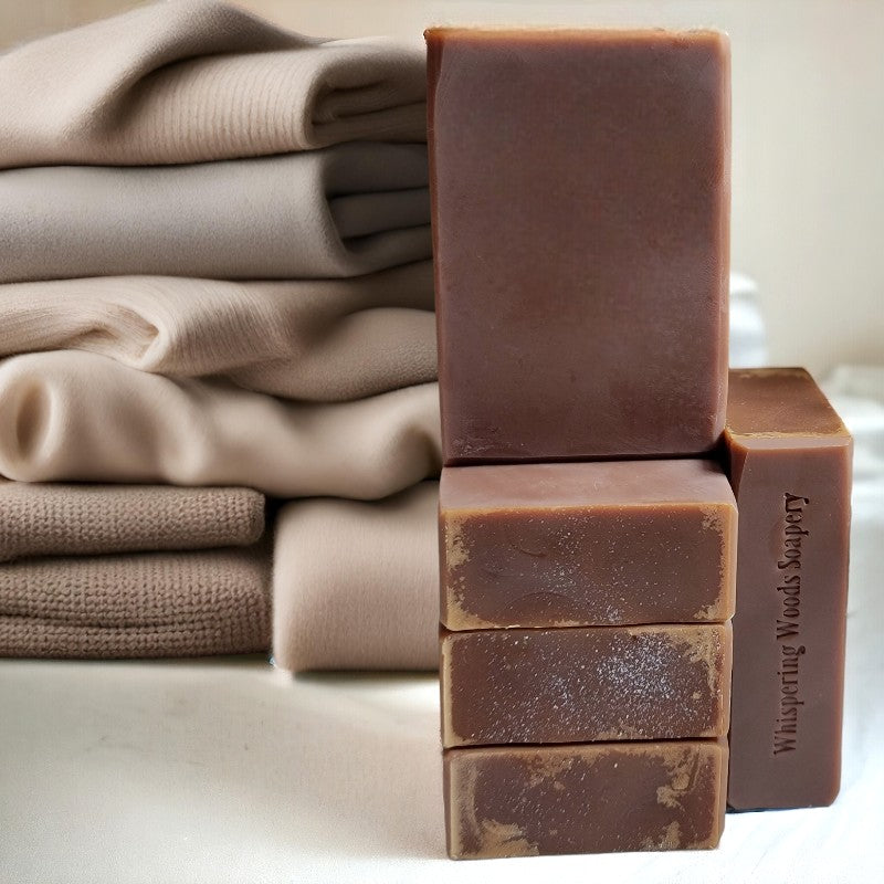 Five beautiful brown bars of soap with a pile of neutral-colored cashmere sweaters in the background