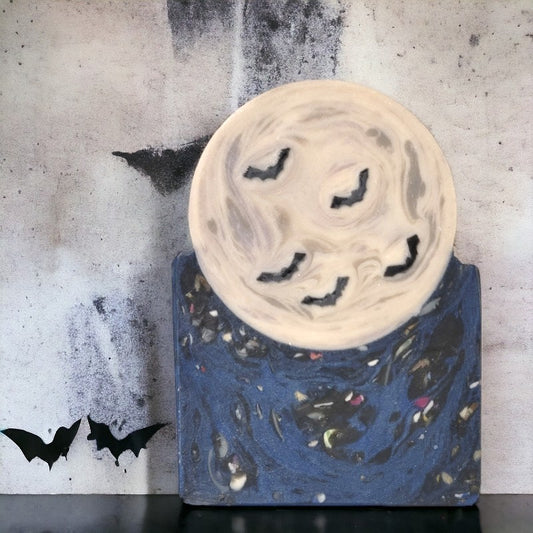 Dark blue speckled soap base with a full moon and bats sitting on it