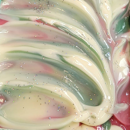 Close-up of wet freshly-poured soap with swirls of pink, green and white and glitter topping