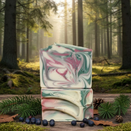 Stack of soap bars with colors of pink and green and white with a forest background