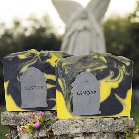 Two bars of yellow and black swirled soaps with a gray tombstone on the front that says LENORE