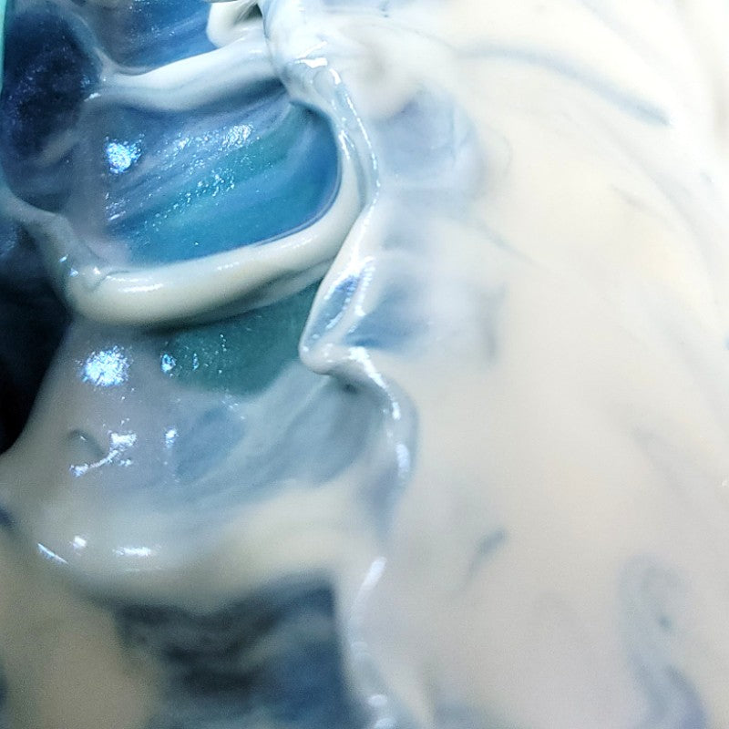 Extreme close-up of freshly poured soap in colors of blue, teal and white