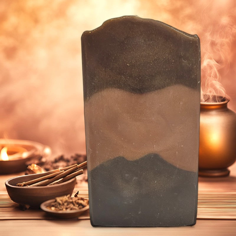 A bar of soap in various shades of brown on a table with incense