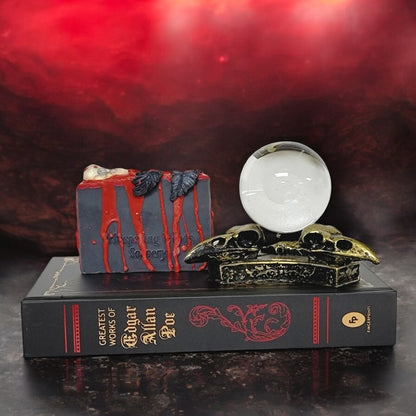 Nevermore Poe collection soap sits on an Edgar Allan Poe book alongside raven skulls holding a crystal ball