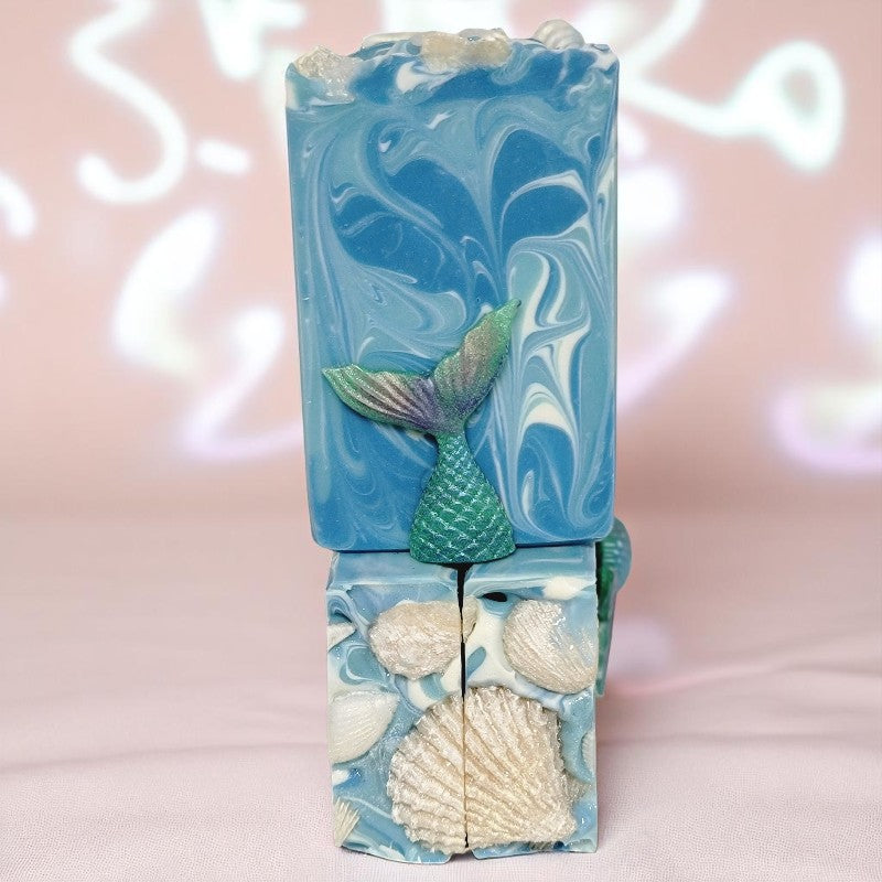 Three bars of soap with swirls of blue and white on a pearly shimmery background.