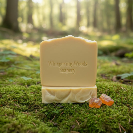 Two light yellow bars of soap sit on a mossy forest bed