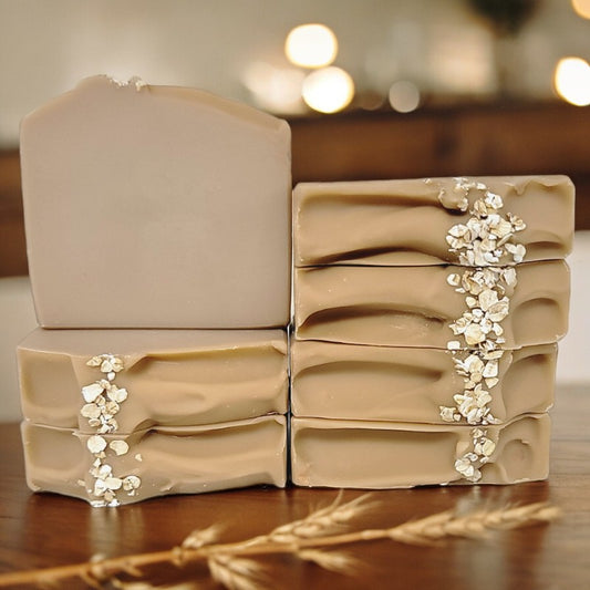 Seven beige-brown soaps with oats on top on a wood table