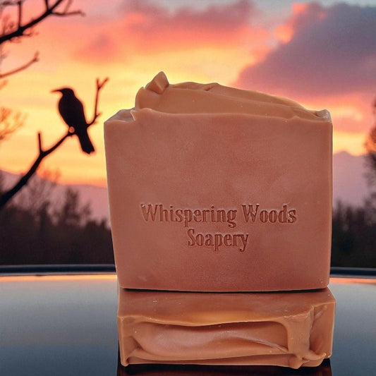 Two dusky rose colored bars of soap with a sunset and raven in the background
