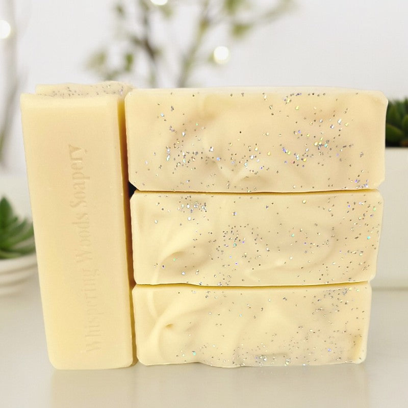 Four bars of pale yellow soap with silver sparkle on top