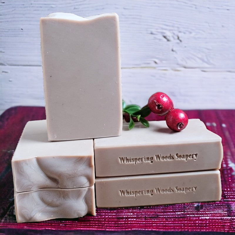 Five light brown bars of soap on a cranberry-colored towel