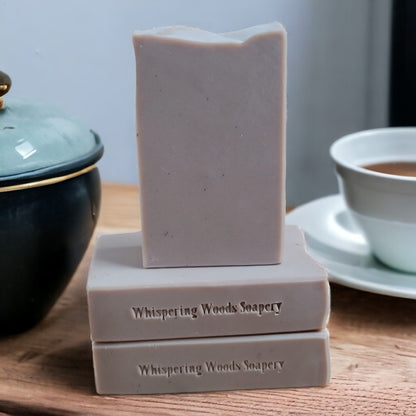 Three light brown bars of soap with a teacup beside them