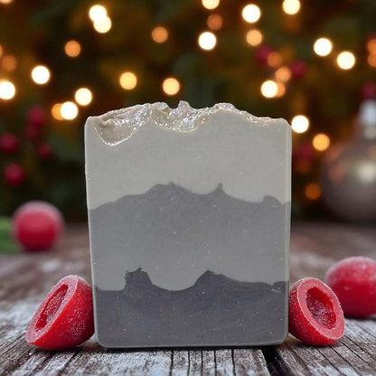 Bar of soap with a layered design on a wooden surface with blurred lights in the background