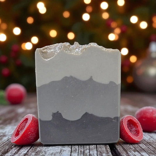Bar of soap with a layered design on a wooden surface with blurred lights in the background