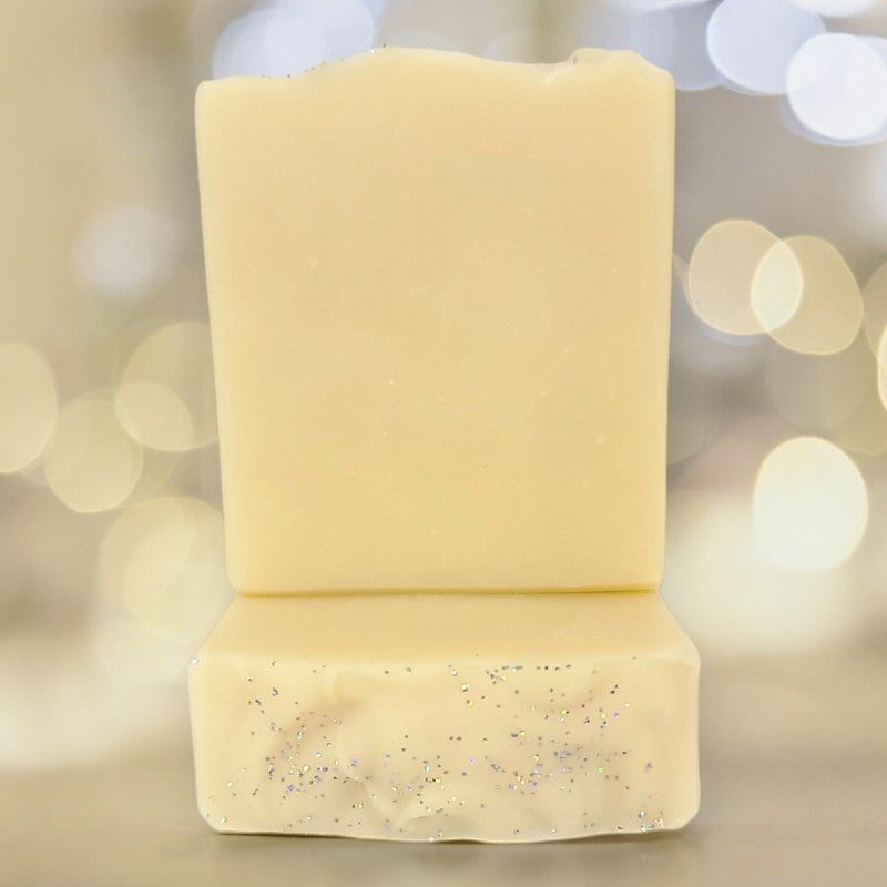 Two bars of pale yellow soap with soft blurry light effects in the background