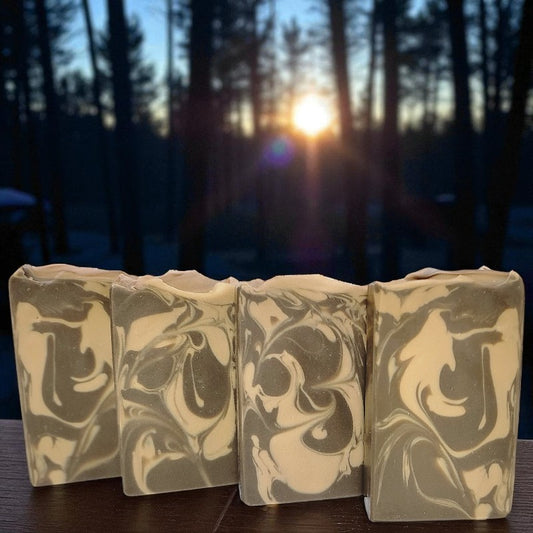 Marbled soap bars on a wooden surface with a forest background