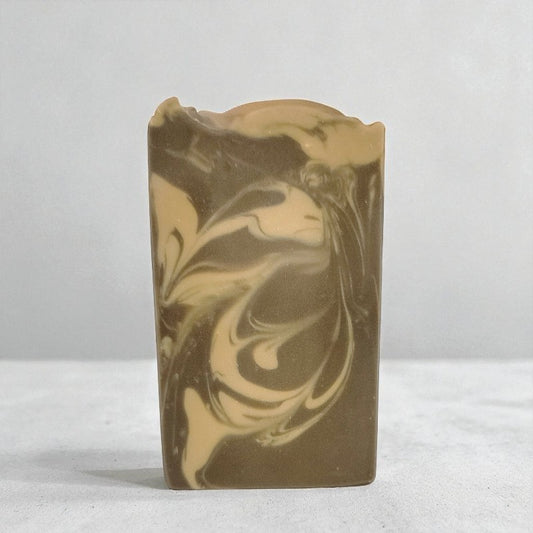Bar of soap with brown and beige swirls on a white background