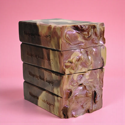 Stack of soap bars with marbled design on a pink background
